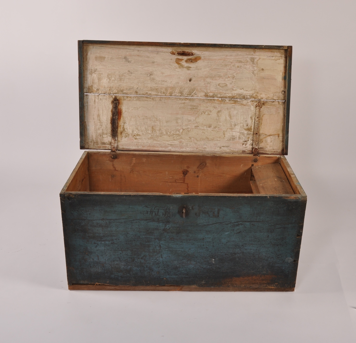 Kiste i tre med flatt lokk med profilerte lister, 2 jernhåndtak. Blåmalt, med rødmalt bakside. Med leddik. Med lås og nøkkel.