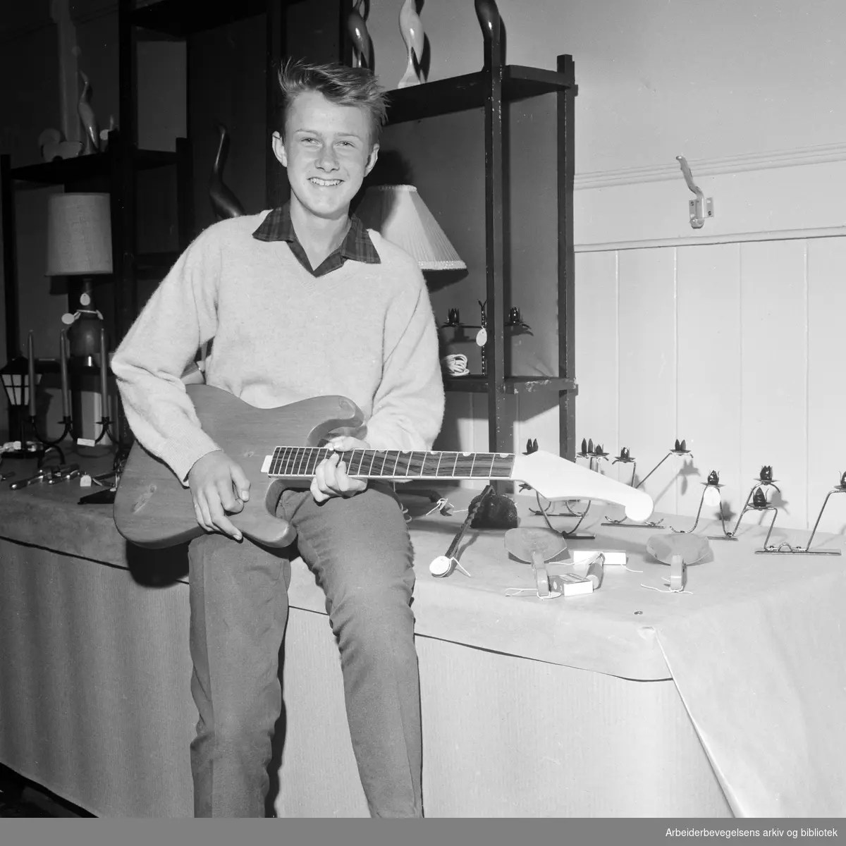 Elever på Framhaldsskolen for gutter på Vaterland stiller ut egne arbeider. Stig Wangberg viser fram en gitar han har laget selv. Juni 1963.