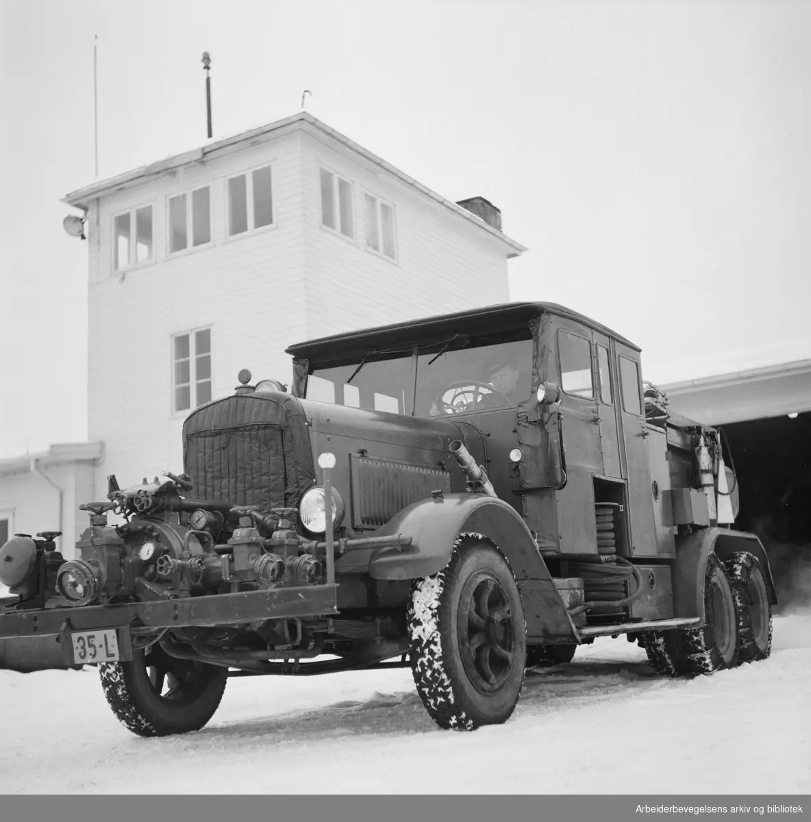 Brannstasjonen på Fornebu med en av skumslukningsbilene. Januar 1951.