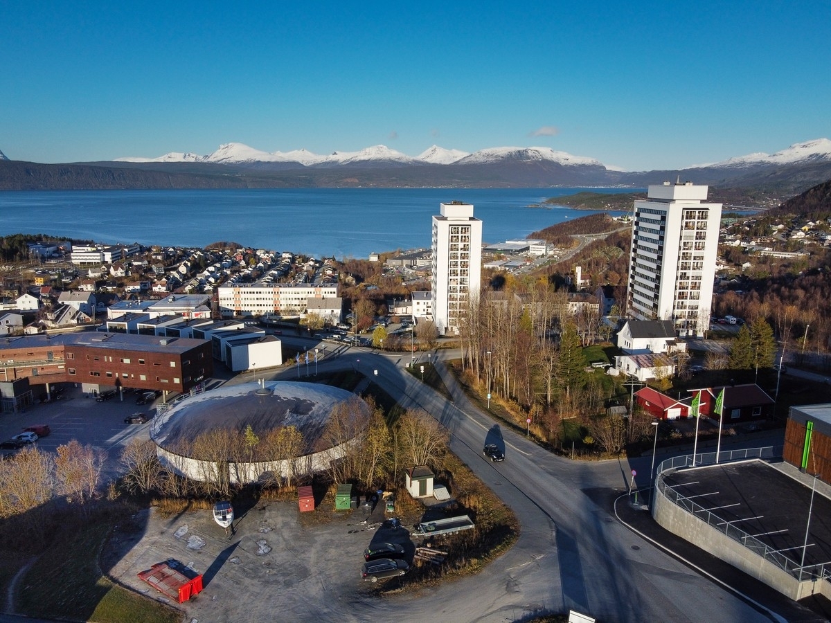 Narvik: Trykkutjevningsbasseng for drikkevann midt på. Til høyre en snipp av nye Kiwi Skistua, og litt utenfor bildet til venstre er Rema 1000 Skistua.  Foto 19. okt 2020.