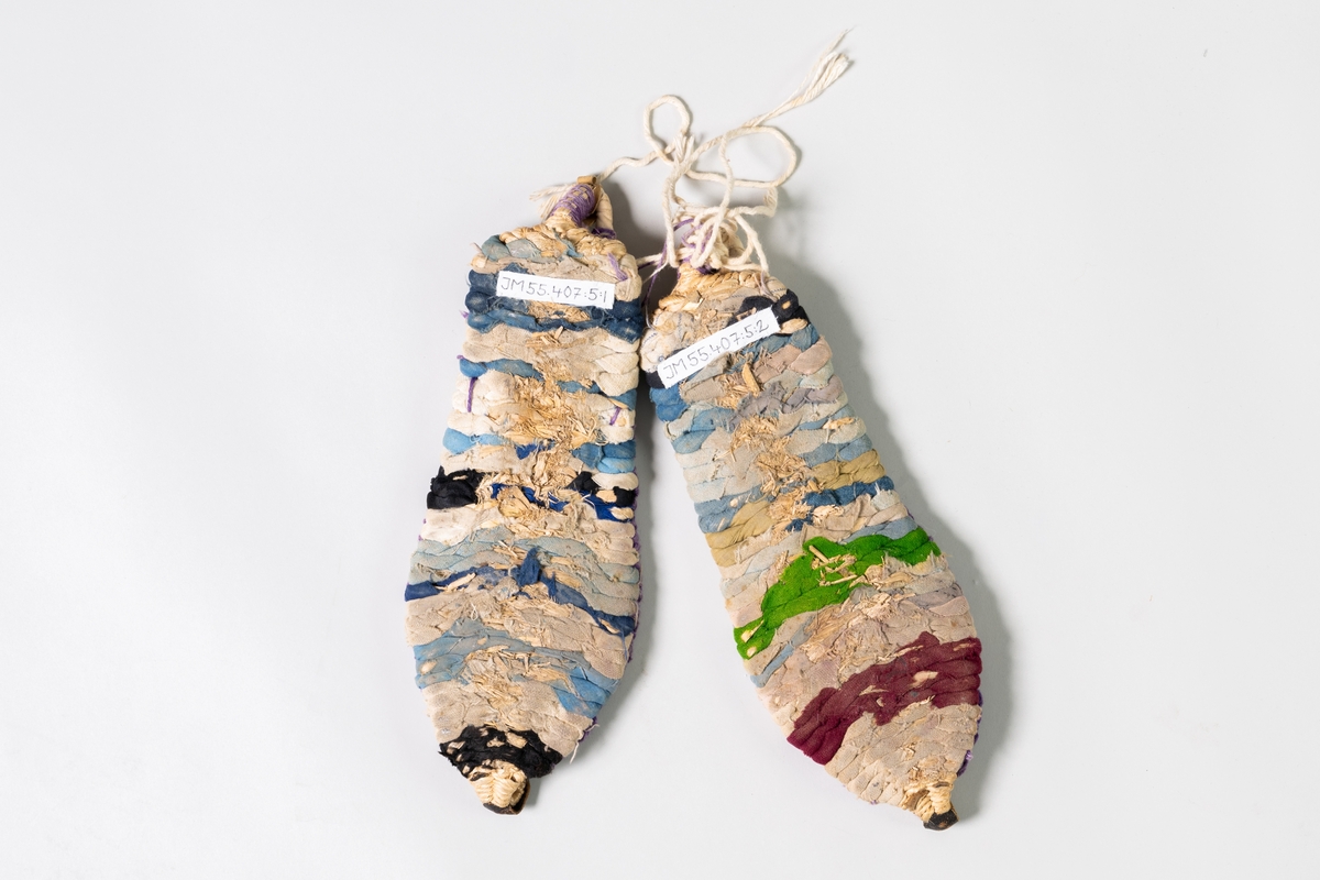 Skor till kvinnodräkt från Kina, sandaler, av bambu klätt med flätade tygband i färgerna vitt, blått, svart, grönt, brunt. Sandalen består av en sula, hälöggla med knytband och en främre del av lilafärgat garn. 

Papperslapp, B5, med anteckningar från givaren är fäst på en av sandalerna. Samhör med JM.55407:1-6.

Se Historik.