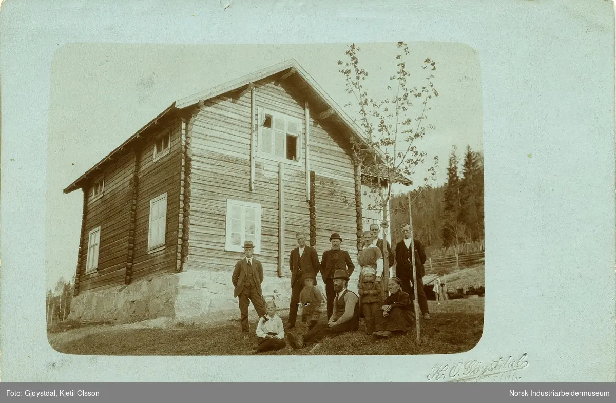 Familien Dahle samlet på tunet utenfor laftet bolighus på Jordet.