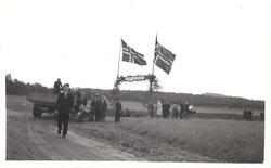 Mennesker i krysset inn til Alstahaug. Banner og flagg i anl