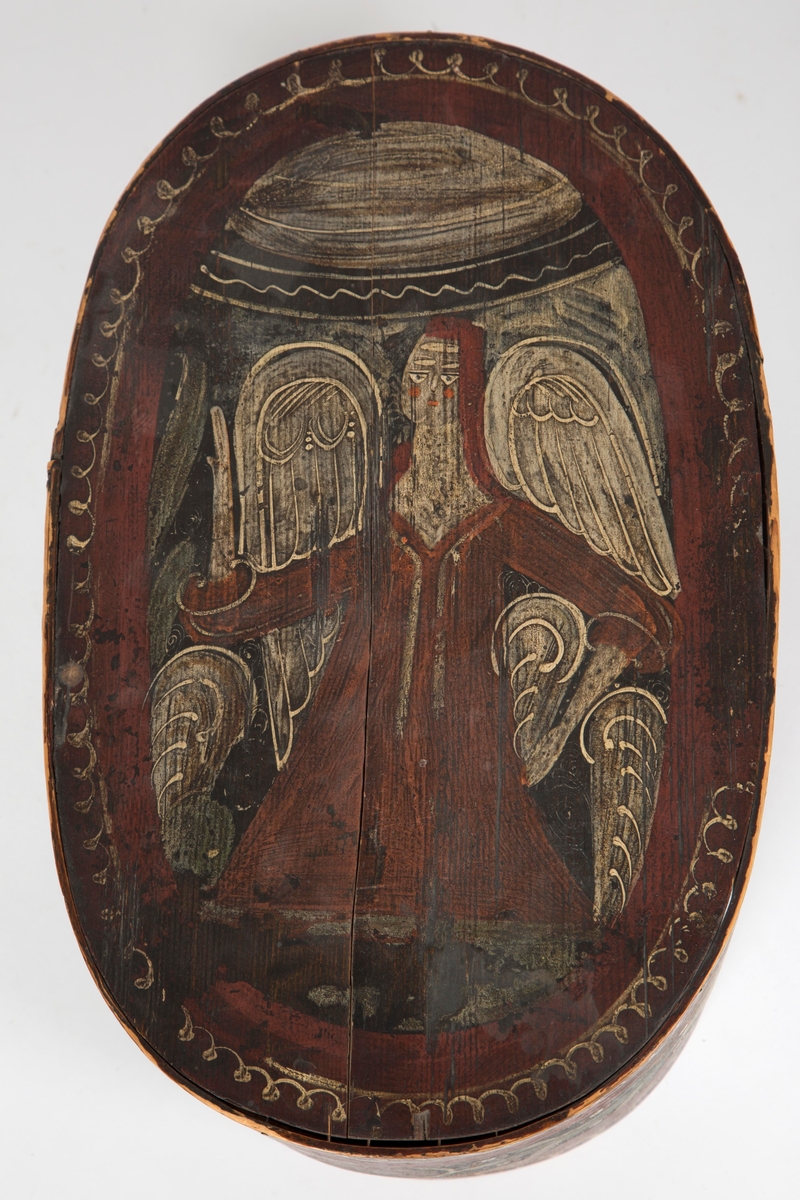 Ovalformet tine med lokk i tre og malte motiver; en engel på lokket og blomster og kruseduller på sidene.