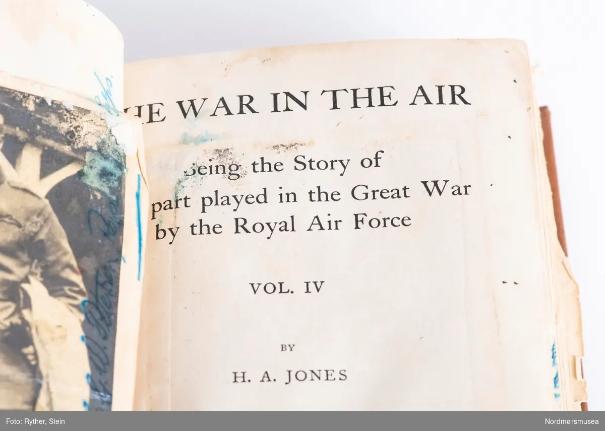 Boken "The war in the air, vol. IV" av H.A Jones. Trykket i 1934 av Clarendon Press, Oxford. Medfølger et monter. Omgjort til et minnealbum av tidligere eier. Inneholder fotografier, håndskrevne ark og tegninger med påført tekst.