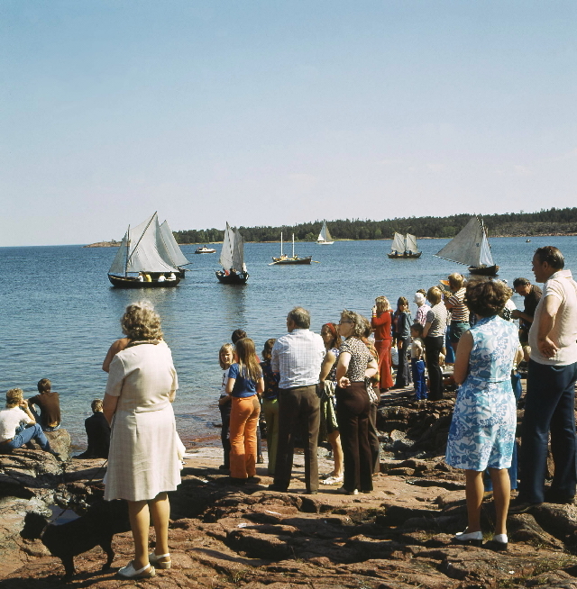 Publiken på stranden väntar att starten skall gå. Båtan är samlade
på start-platsen vid Eckerö.