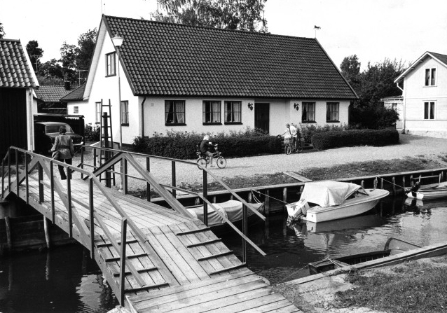 Nils Olsson lämnar post i postlådan hos familjen Wilsson, som har
sitt hus in-till ån, där fritidsbåtarna ligger nära varandra.