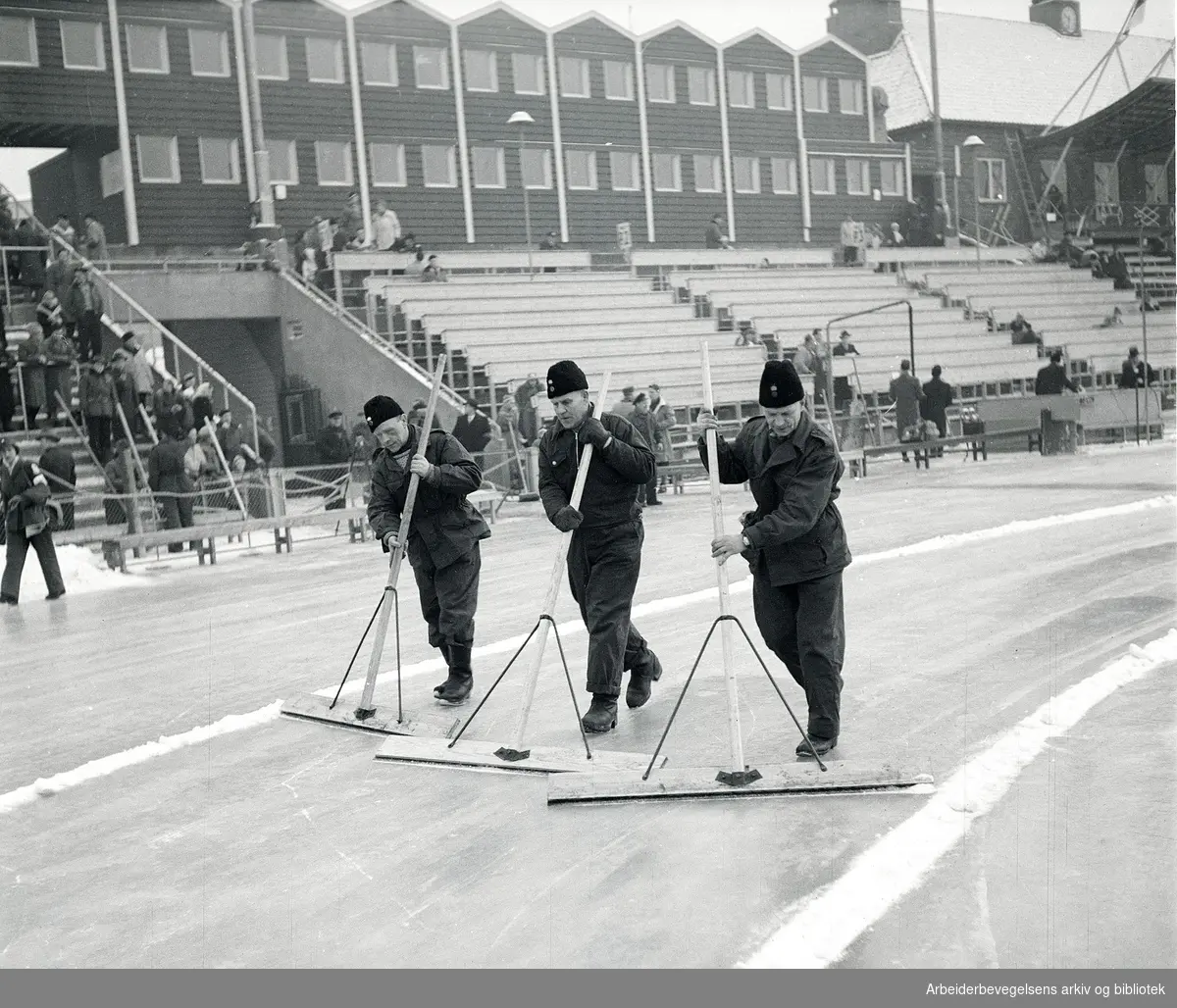 Banemannskapet på Bislett Stadion preparerer isen før hurtigløpene på skøyter under vinter-ol i Oslo, februar 1952