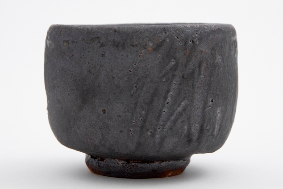 Asiatisk inspirert tebolle i dreid steingods, med et abstrakt stråaktig motiv under en blågrå glasur.