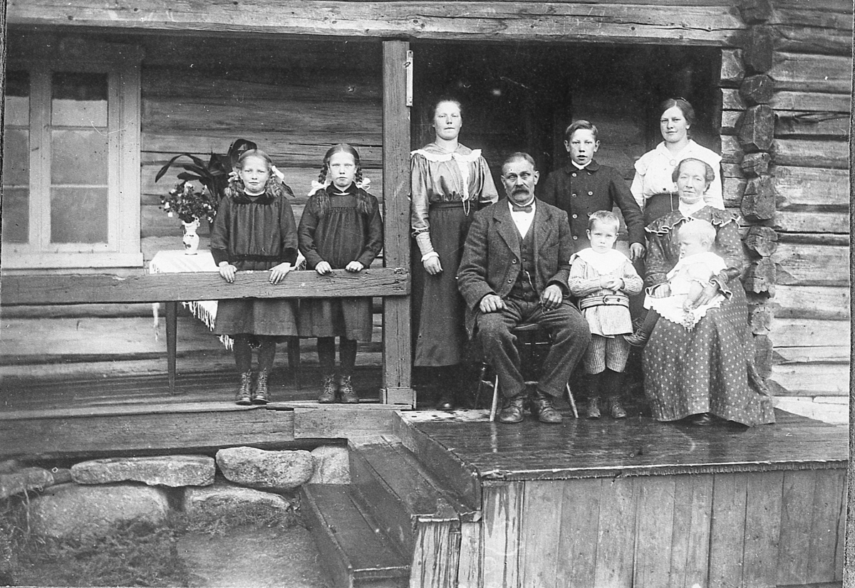 Kari og Engebret Rustand (Lien) med familie, på verandaen på Rustand ca. 1912. Barna, fra venstre: Paula, Olava, Borghild, Kristian, Kristine, Per og Anna.