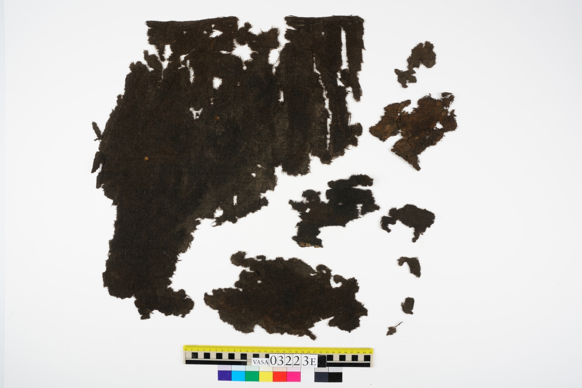 De textilier som hittades i samband med "skelett A" eller Adam som han också har kommit att kallas är fyndnummer 03193 och 03223a-e. Textilfynden är så kallade dykarfynd vilket innebär att de togs upp från Vasa under maj 1960 innan skeppet bärgades. Merparten av "skelett A" hämtades upp samtidigt som dessa textilfynd. Både de textila fynden och skelettdelarna hittades på övre batteridäck, på styrbord sida mellan balk 5-6.
 
Fyndnummer 03223 innehåller 37 textilfragment vilka består av sex olika tyger, uppdelade på fem askar (a-e). Samtliga fragment är vävda av ull men med olika vävtekniker och i olika grovlekar och kvalitéer på garnet. Flera av fragmenten har spår av sömmar och tillskärning vilket tyder på att de kan ha varit delar av klädesplagg. I askarna 03223c och e finns dels fragment av samma tyg men även fragment med mycket liknande, dock inte samma, karaktär på vävens utseende, yta och egenskaper. Fragmenten har även överensstämmande tillskärning, spår av sömmar, veckning och bristningsmönster som tyder på att de ursprungligen varit delar av en byxa. Det är möjligt att fragmenten, trots att de kommer från olika tyger tillsammans har utgjort ett och samma par byxor.
 
 För mer detaljerad information från textildokumentationen (år 2020) se länkade filer.