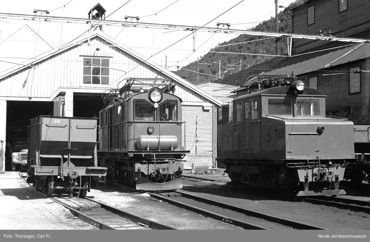 Thamshavnbanens elektriske lokomotiv nr. 5 (til høyre) og nr. 7 eller 8 foran lokomotivstallen på Thamshavn stasjon. Til venstre kisvogn nr. 136
