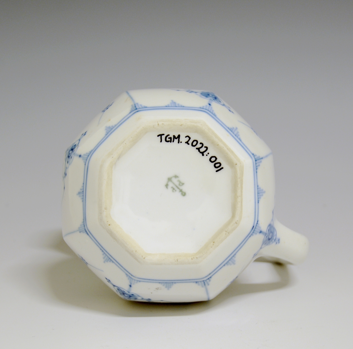 Melkemugge av porselen med hvit glasur. Høy, kantet hank. Dekorert med stråmønsteri blått.

Modellnr: 1746
Finnes i priskuranten for 1924.