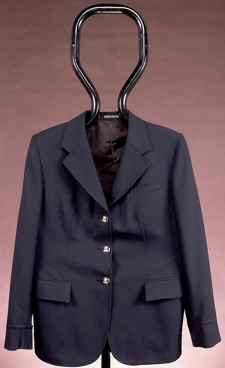 Uniform m/1984 för kvinna. Jacka, skjorta och säkerhetsslips. Kjol/byxa saknas.