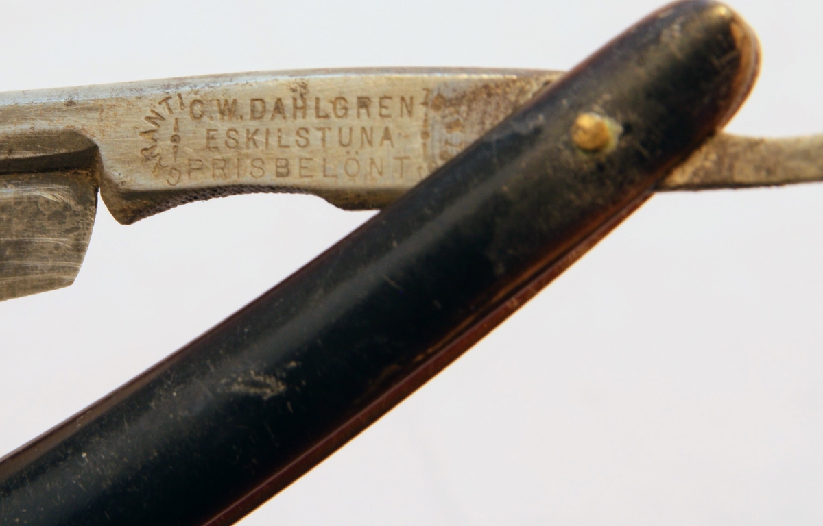 Rakkniv med handtag i plast och bladet i metall.  Texten "Garanti C.W. Dahlgren Eskilstuna Prisbelönt 1878 1881" står skriven på bladets nedersta del.