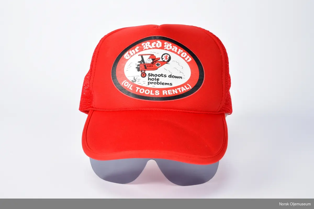 Skyggelue med reklame for boreutstyr selskapet The Red Baron. Luen er utstyrt med solbriller.