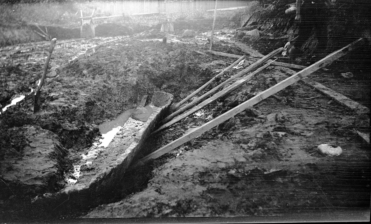 En halv stockbåt från medeltiden dras med hjälp av träbjälkar upp ur den inre vallgraven i samband med arkeologiska undersökningar vid Rumlaborg i Huskvarna sommaren 1932.