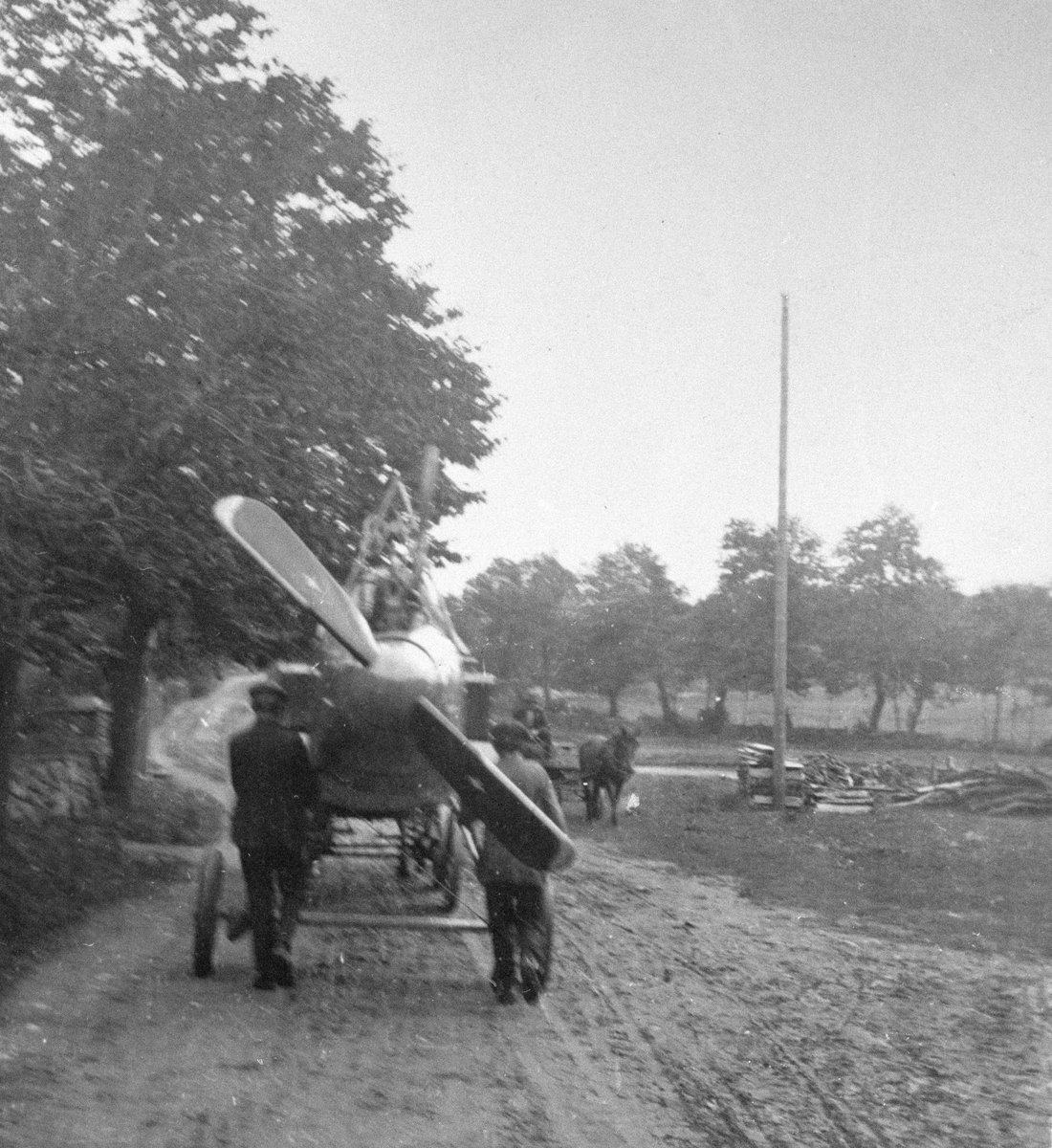 Flygplan Thulin FA med vingar bortmonterade bogseras längs en landsväg ...