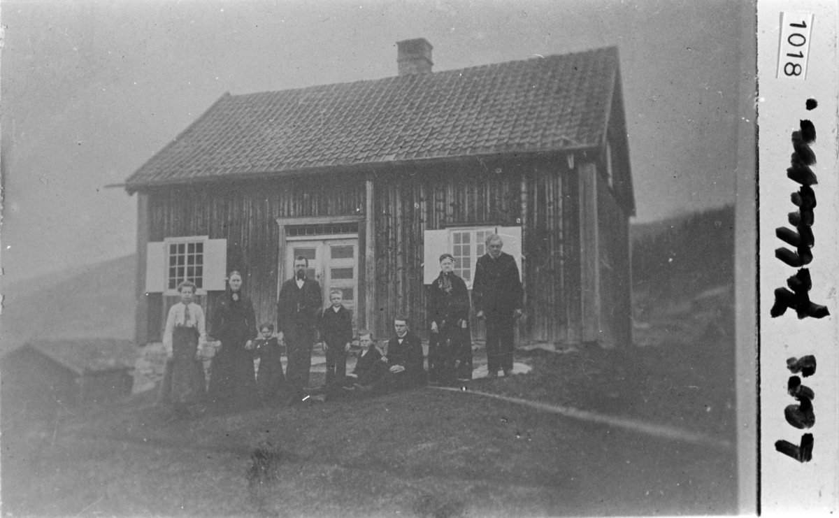 Familie foran det gamle huset på Jellum, ca. 1900-10. Fra venstre: Anne, Kari, Gjertrud, en ukjent, Nils (usikker), Knut (usikker), Anne og Knut Jellum.