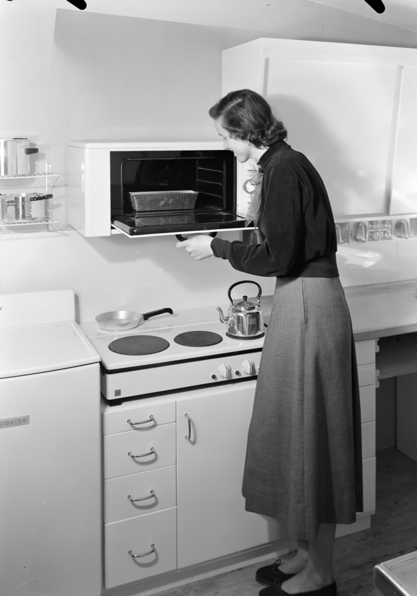 Kvinne på kjøkken med komfyr.