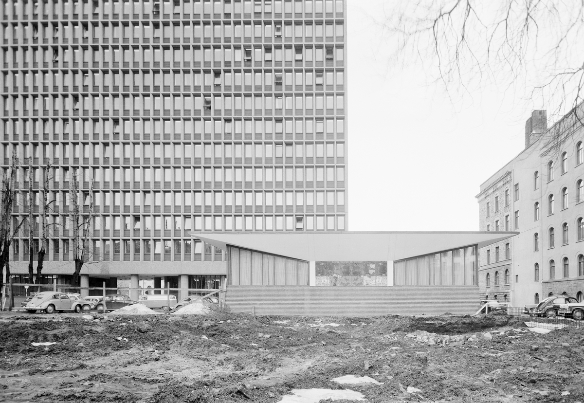 Fasadebilde av Høyblokka i Regjeringskvartalet, med møteromsannekset på Akersgate-siden. Til høyre Den gamle regjeringsbygning.