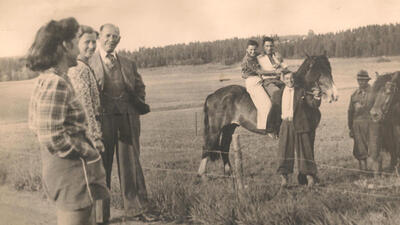 Bildet i svart/hvitt og viser en jødisk familie på et jorde. Flere barn sitter oppå en hest.. Foto/Photo