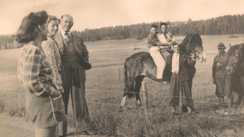 Bildet i svart/hvitt og viser en jødisk familie på et jorde. Flere barn sitter oppå en hest.