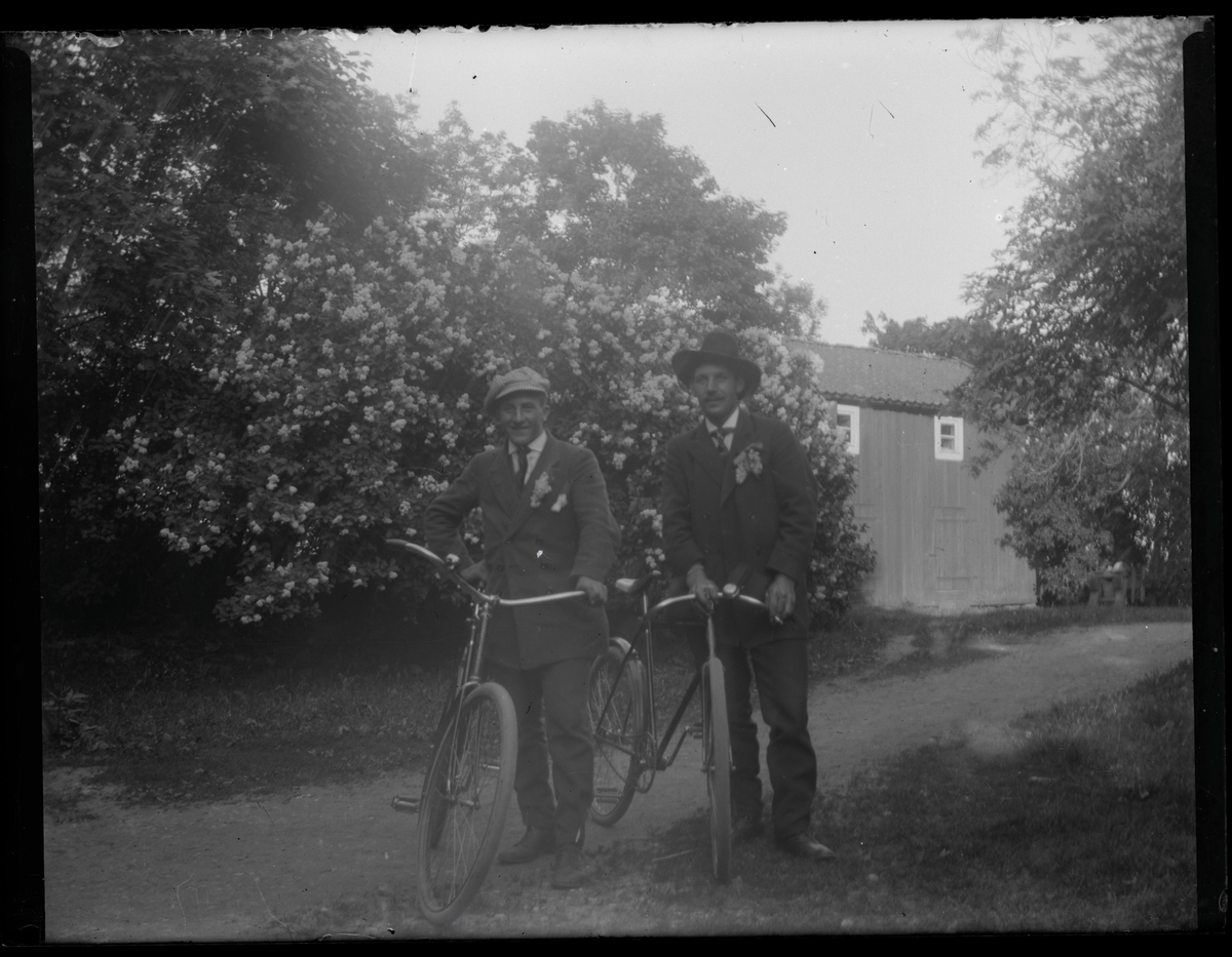 Grupporträtt, två män med cyklar.