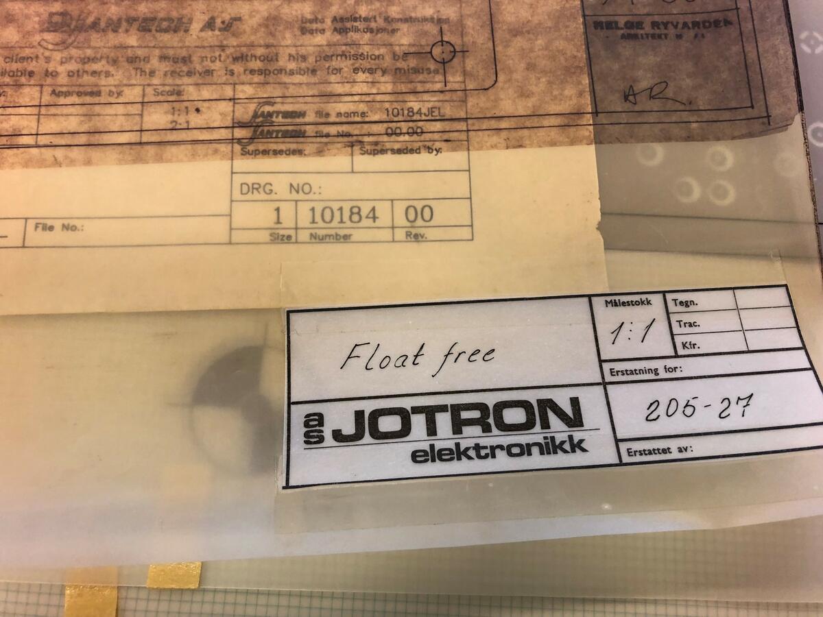 Bildet viser et nærbilde av gjennomsiktige ark/ tegninger i en bunke. På en etikett står det JOTRON.