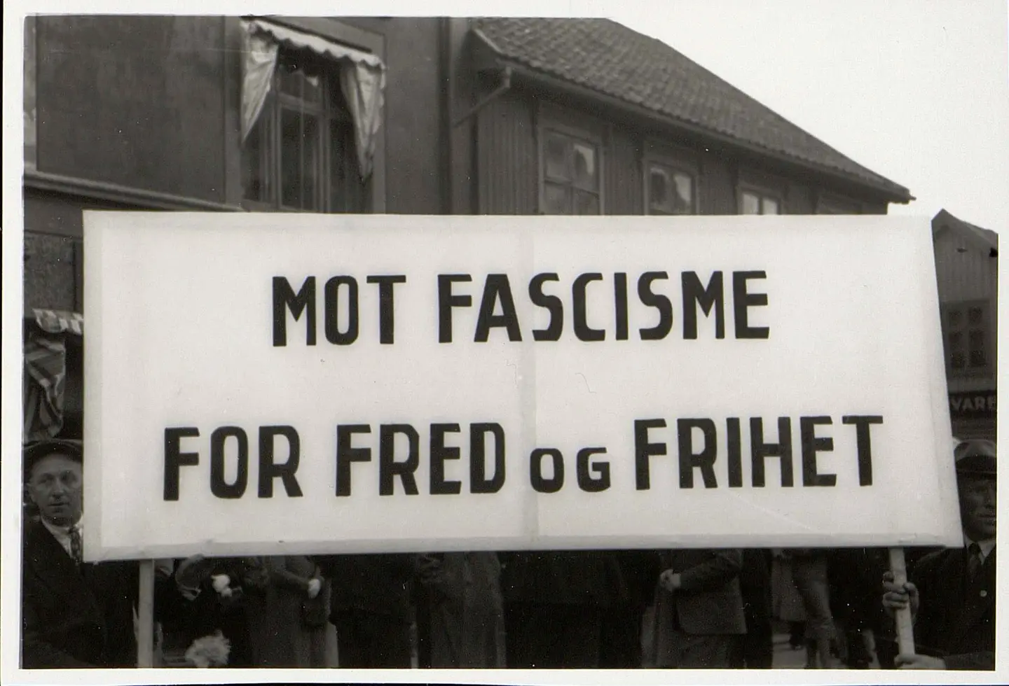 Sort-hvitt-bilde som viser en fane der det står Mot fascisme for fred og frihet