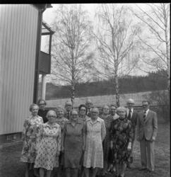 En grupp äldre kvinnor och uppställda intill en byggnad.