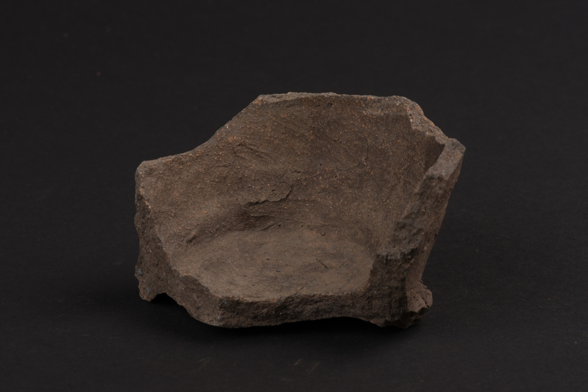 Fragment av lerkärl från medeltiden.
Består av botten, något utkragat, och del av sidan.