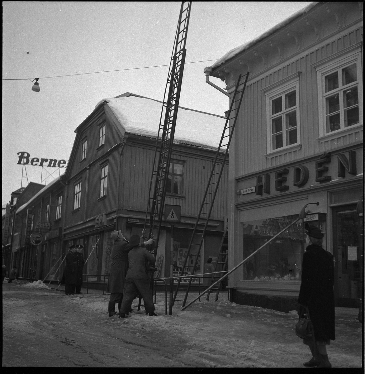 Hedéns hörna, kv Kronan. Kungsgatan. Röjer snö från taket. 31 jan 1951
