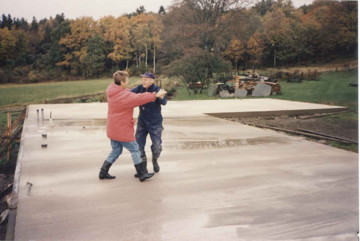 Långåker 1:3 1992-10-18. Karin Gustafsson och Lars Erik Andersson tar sig en svängom på den nygjutna grundplattan vid bygget av ladugården,