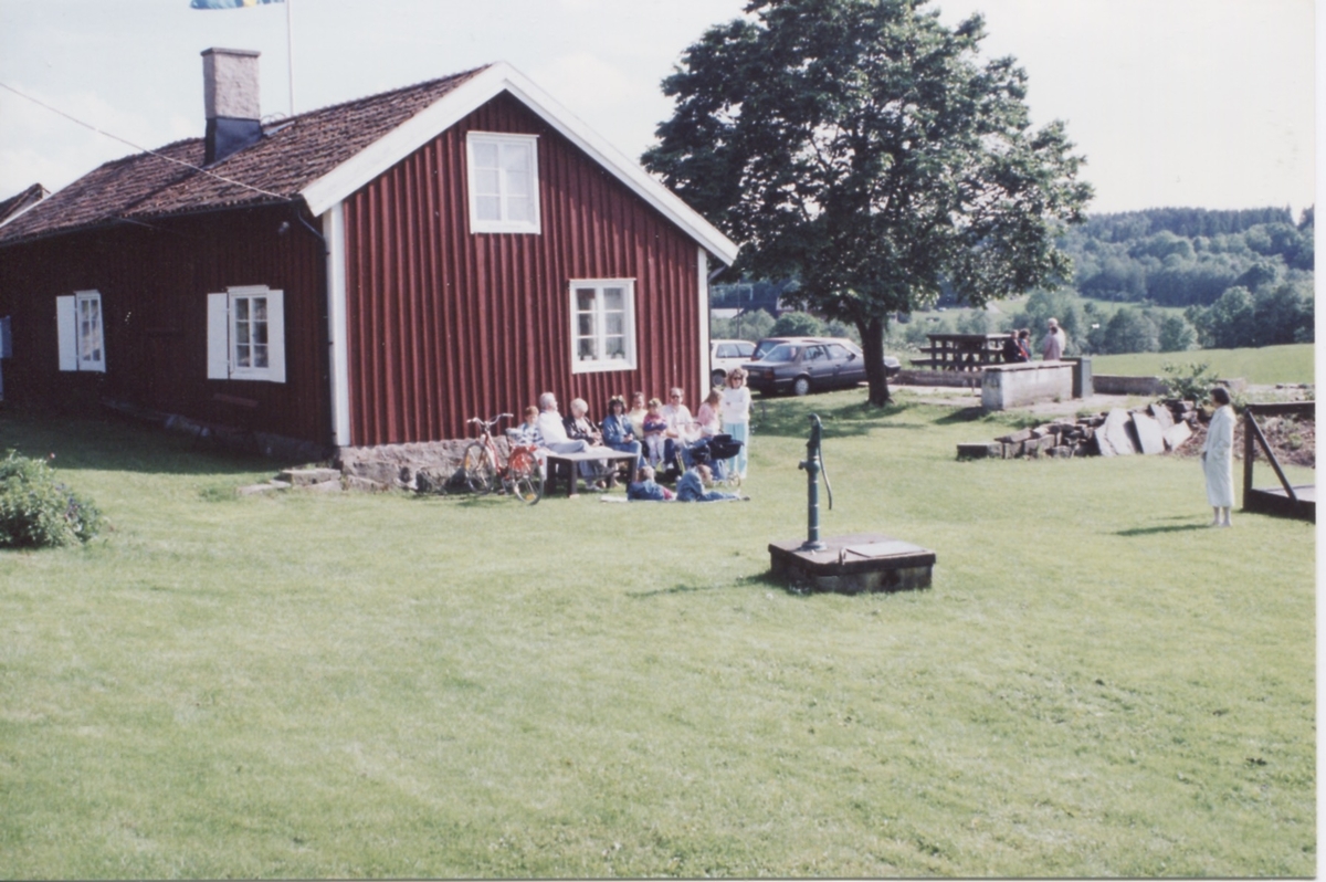 Personer sitter och fikar utanför hembygdsgården Långåker 1:3 innan 1990.