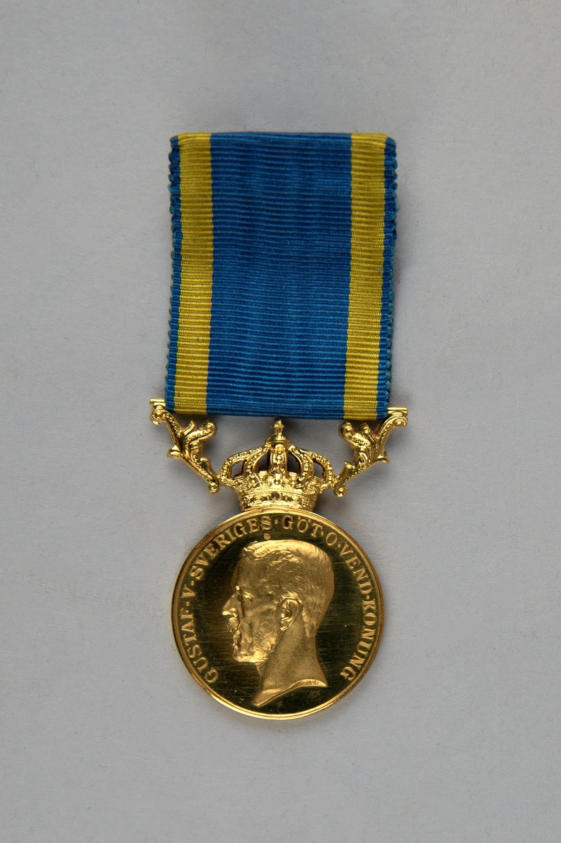 Guldmedalj (:1) i ask (:2). 
Medaljen pryds av Gustaf V:s profil på ena sidan med texten "GUSTAF.V.SVERIGES.GÖT-O-VEND.KONUNG", konsnärens initialer ingraverade under porträttet "AL".  På den andra sidan står det "FÖR.NIT.OCH.REDLIGHET.I.RIKETS.TJÄNST TILL CARL ADOLF LIND". Medaljens rundel kröns av en kunglig krona. 
På medaljen är fäst ett blågult band för fastsättning.
Medaljen ligger i en röd ask. Insidan av asken är klädd med lila textil. Asken har ett litet mässingslås.
