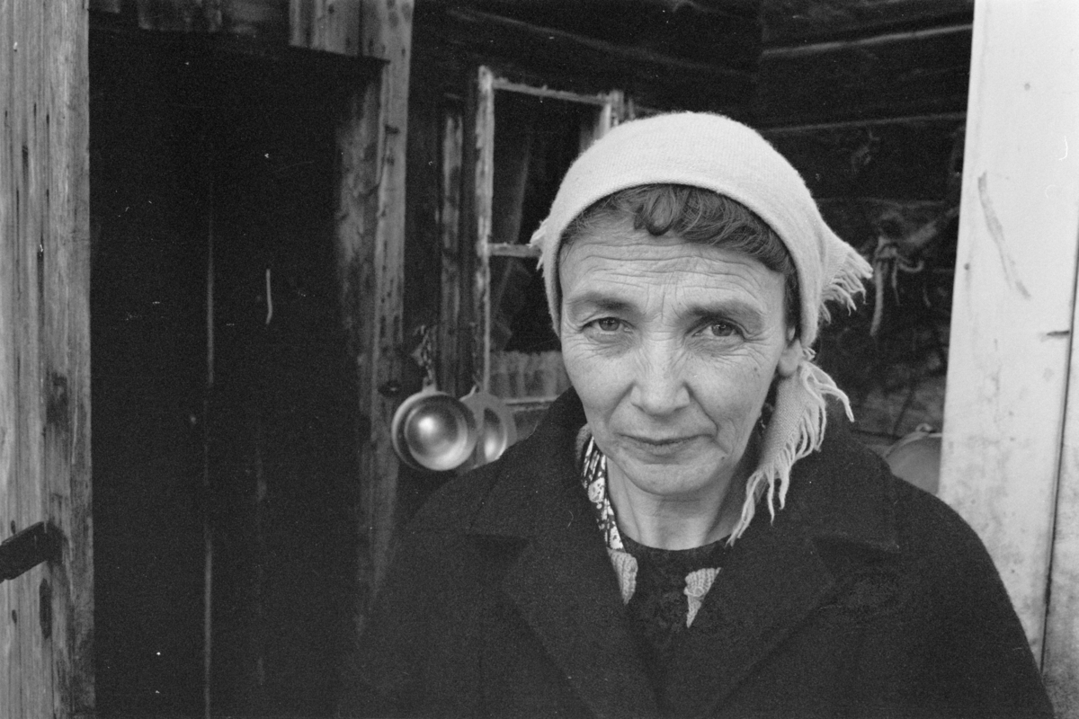 Portrett av en kvinne i gang med melkestell i et gårdsrom på Røros.