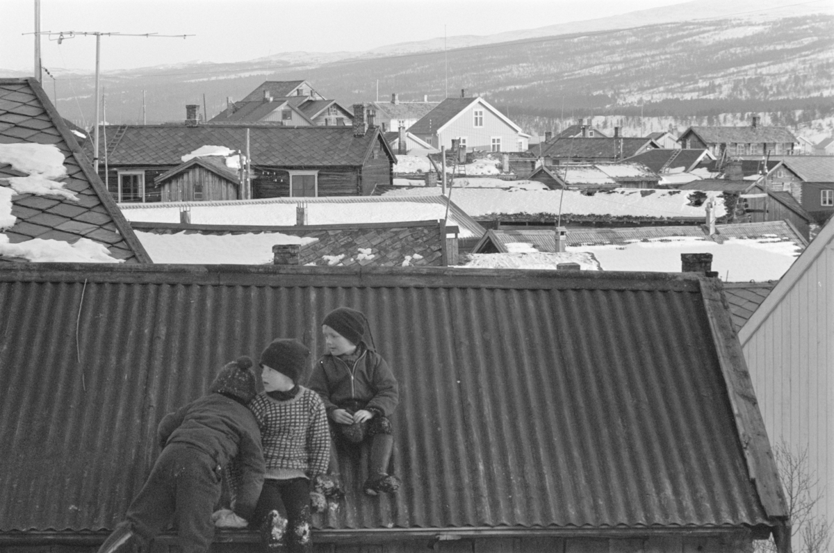 Barn leker i et snødekt bylandskap på Røros.