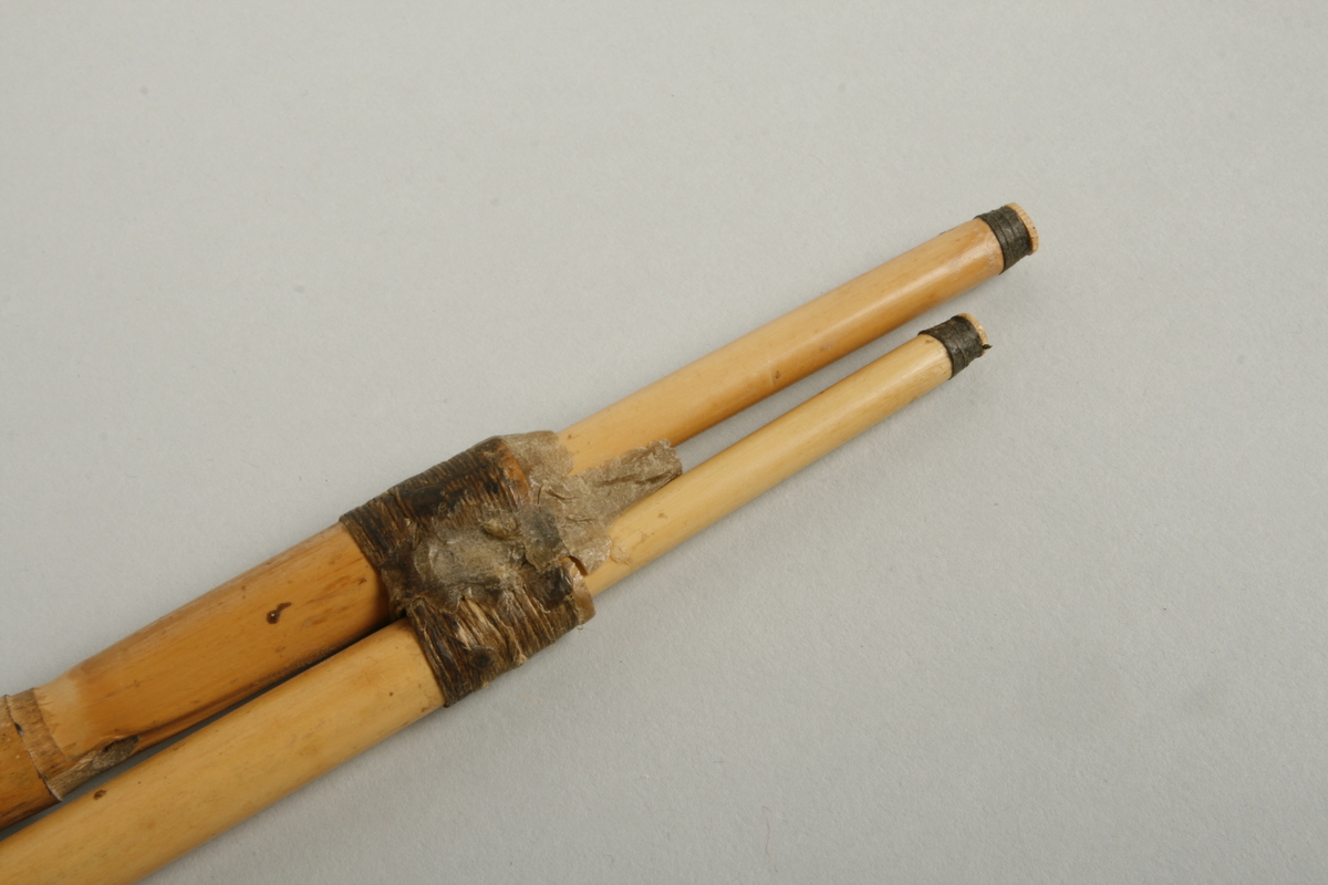 Trippelskalmeie av bambusrør. Tre rør hvorav to, en spillpipe og en bordunpipe, er festet sammen to steder. Det tredje røret, en spillpipe, er løst. Munnstykket er også av bambus og er festet med voks til de sammensatte pipene. Den tredje pipen er løst satt nedi. Instrumentet har enkle rørblad skåret ut av selve munnstykket-treet. Bordunpipen er sammensatt av to deler.