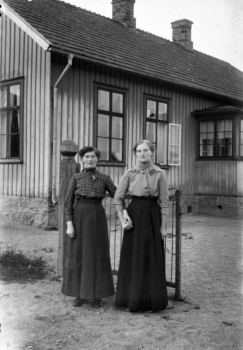 Småskolan i Sundbo, Sällstorp. Vid grinden står Alma från Jel i Ulvatorp med en annan kvinna och håller varandra i hand.
