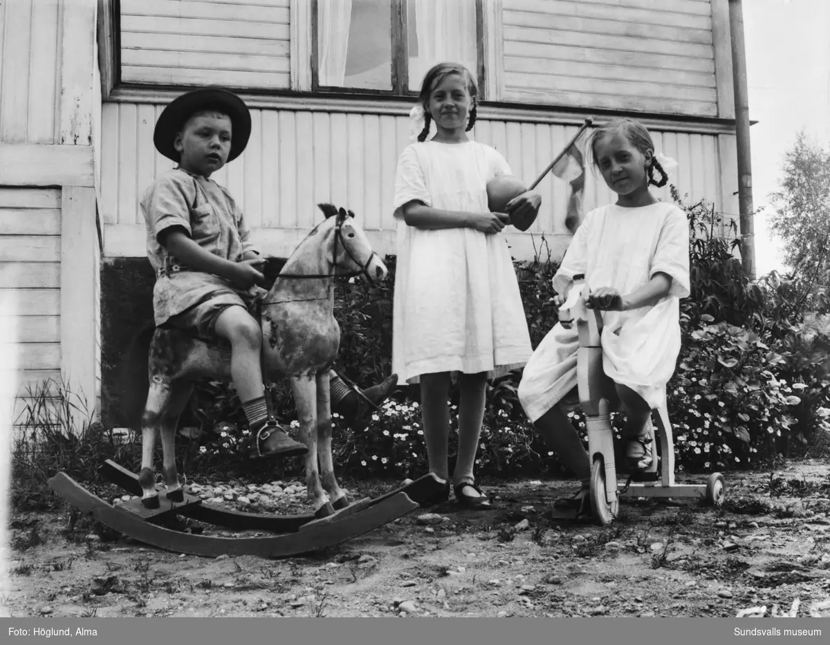 Tvillingsystrarna Ingrid och Irma Höglund samt Thure Wikberg. På andra bilden Thure på en leksakshäst.