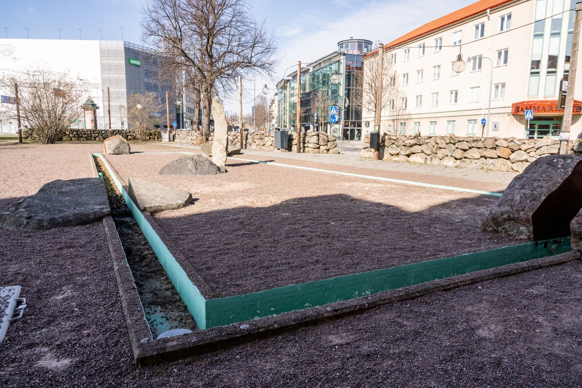 Stenkonstverk bestående av tillhuggna eller naturligt formade stenblock, klyvna i delar, som partiellt sågats, slipats och polerats. Därefter är delarna hopfogade till de ursprungliga blockens former, men med många ursparningar. Stenformationerna blir därmed byggda av tomrum och massa med naturligt skrovliga och högglanspolerade ytor. Sammanlagt 12 stenblock är placerade intill, innanför, utanför eller över en fyrsidig, smal, betonggjuten vattenränna. Rännan är utformad med två långsidor och två kortsidor, de senare med olika längd. Rännan ligger i nivå med den omgivande grusade markytan, och är fylld med cirkulerande vatten. Vattenrännan har (2022) en sentida turkos bemålning. Sammanlagt 12 stenblock.

1. Gnejs, Smålandsstenar
2. Diabas, Rydaholm 
3. Sandsten, Visingsöformationen, Uppgränna 
4. Sandsten, Visingsöformationen, Uppgränna
5. Tabergsmalm, Taberg
6. Konglomerat, Vetlandaserien, Vetlanda
7. Diabas, Rydaholm
8. Röd granit, Askeryd