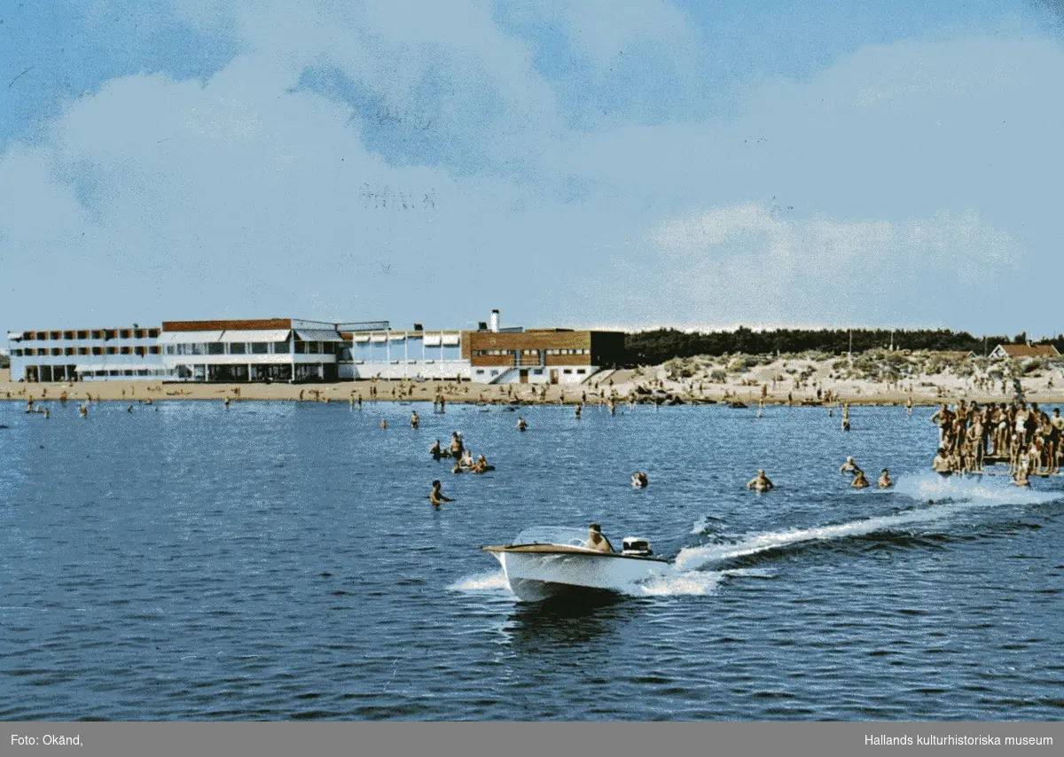 Vykort avsänt 1966 i färg med en motorbåt och badande människor i havet med hotell Strandbaden i bakgrunden.