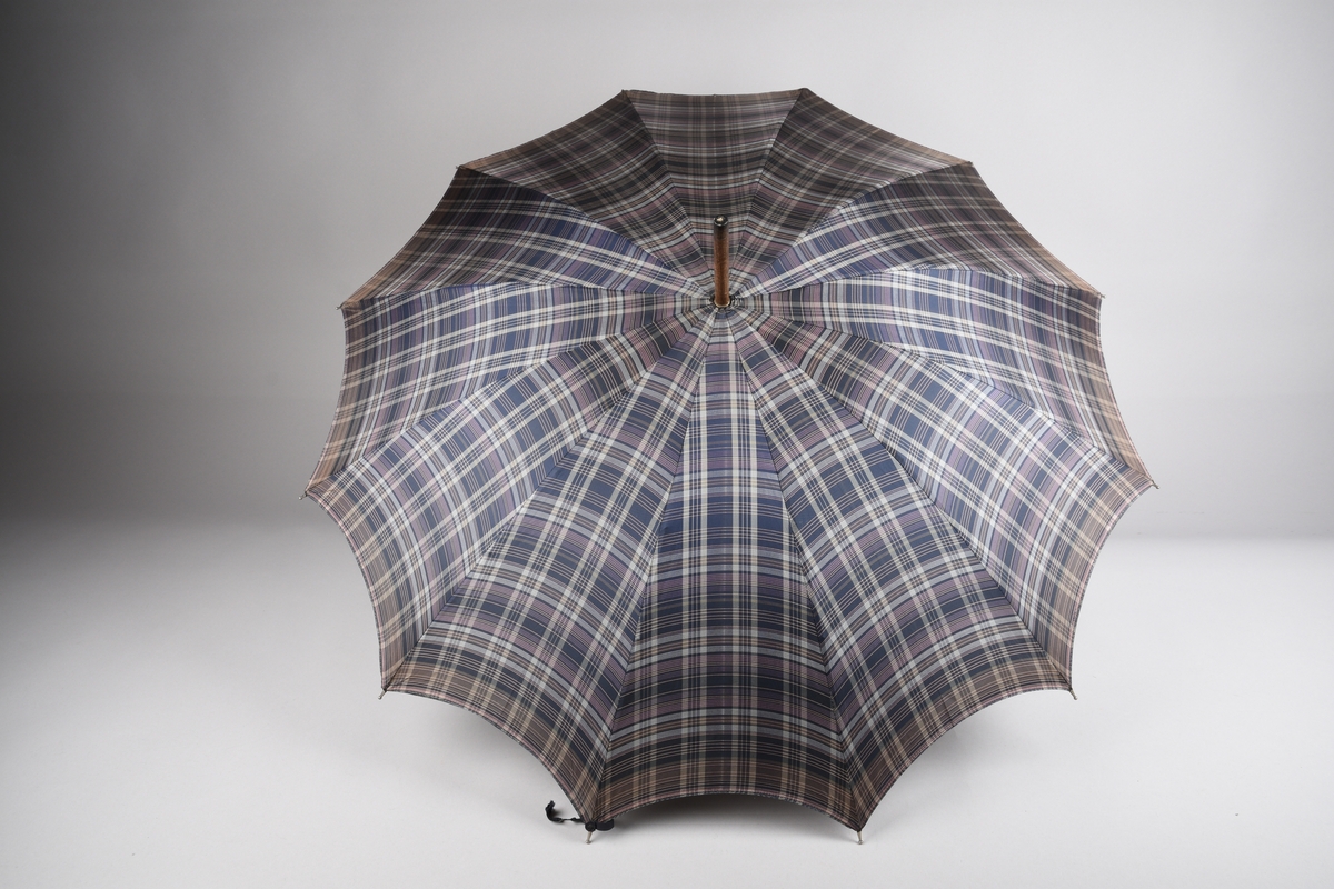 Paraply med 12 metallspilar. Stong i tre. Trekt med stoff i kunstfiber, rutemønster. Handtak i tre med hempe i tekstil til å ta inn på handa. Hempe for lukking av paraplyen.