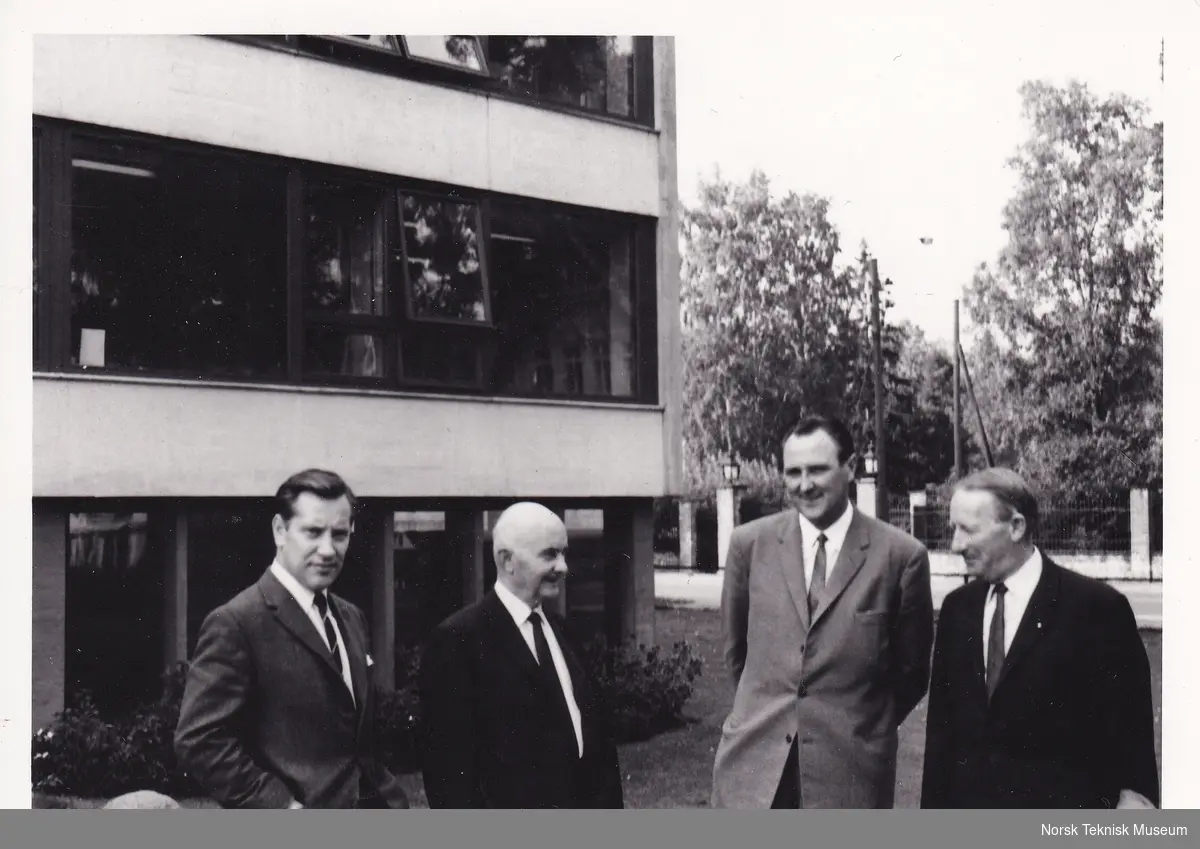 Elkos direktører Knut Ervik (t.v.) og Kaare Kristensen (nr. 3 fra v.) sammen med to ukjente eldre menn utenfor Elko-fabrikken i Sandvika, trolig midt på 1960-tallet.