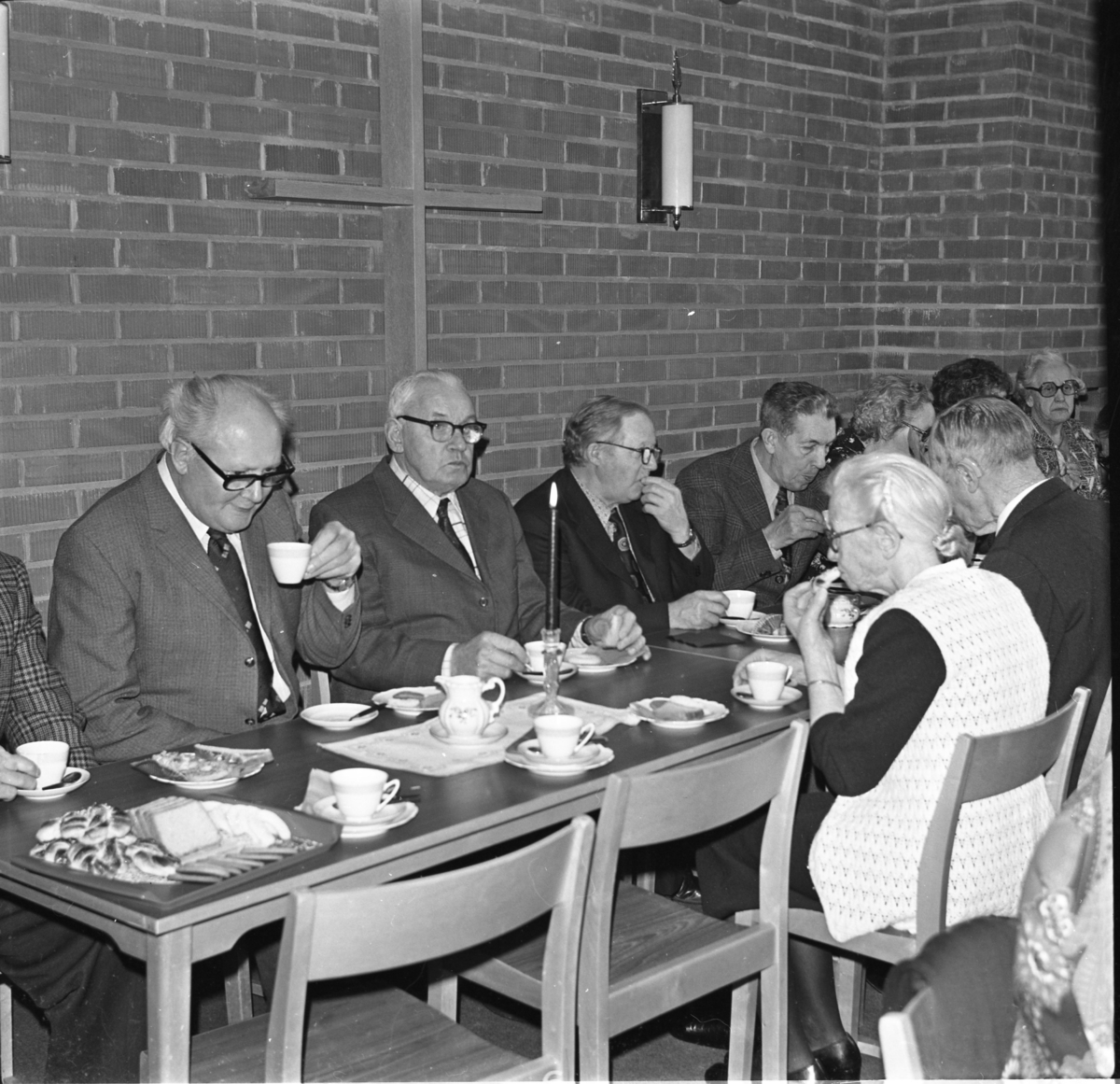 Äldre kvinnor och män sitter vid kaffebord med tända ljus. Det är Filadelfia-församlingen i Gränna som arrangerar "De äldres fest".