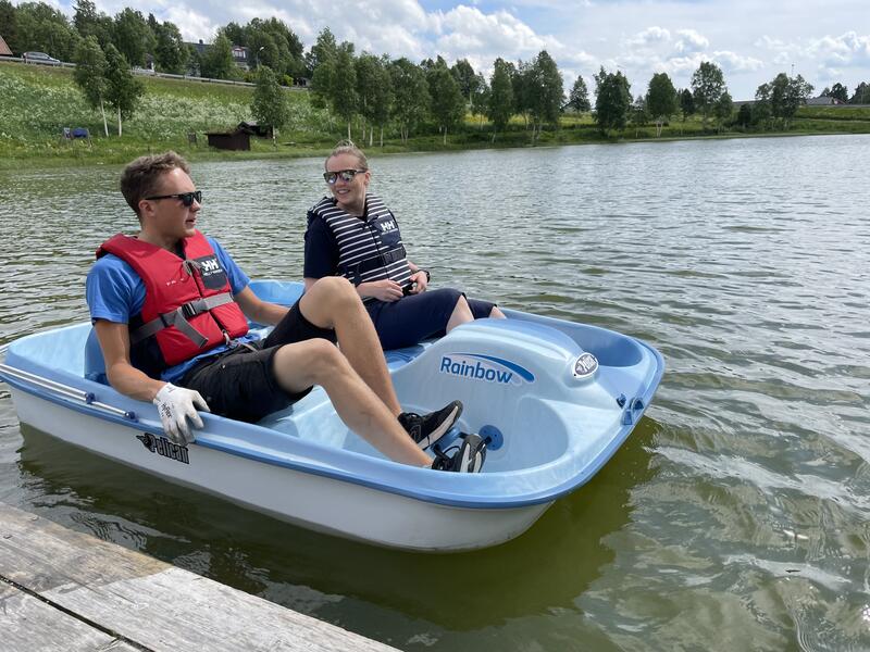 To mennesker sitter i en pedalbåt og smiler til hverandre. De er ute på Doktortjønna på Røros. (Foto/Photo)