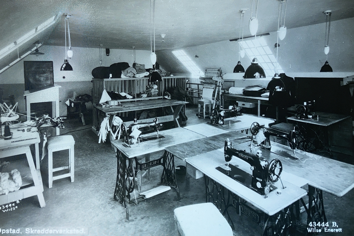 Interiørbilde fra skredderverkstedet ved Opstad tvangsarbeidshus. Arbeidsbenker og  symaskiner.