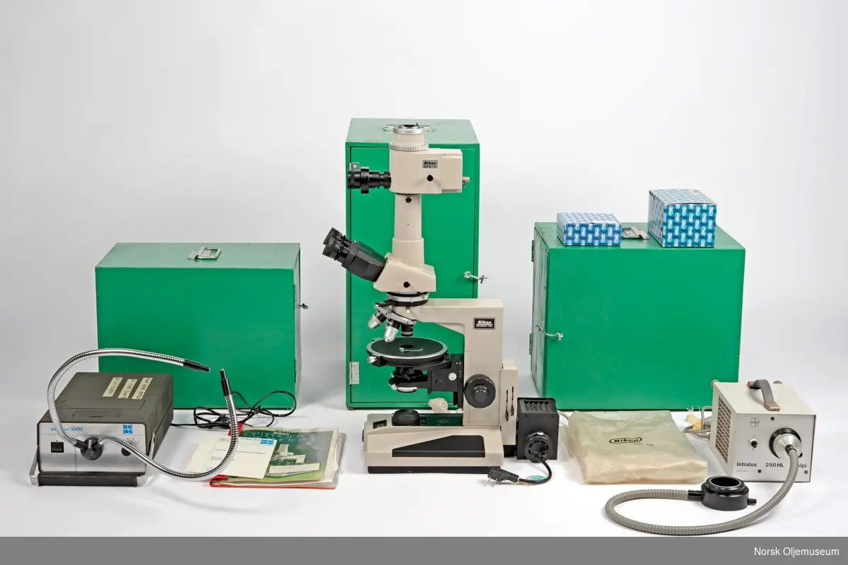 Laboratorieutstyr bestående av et analysemikroskop med ekstrautstyr og to apparater for fiberoptisk belysning. Tre bærbare kasser for transport hører til utstyret.