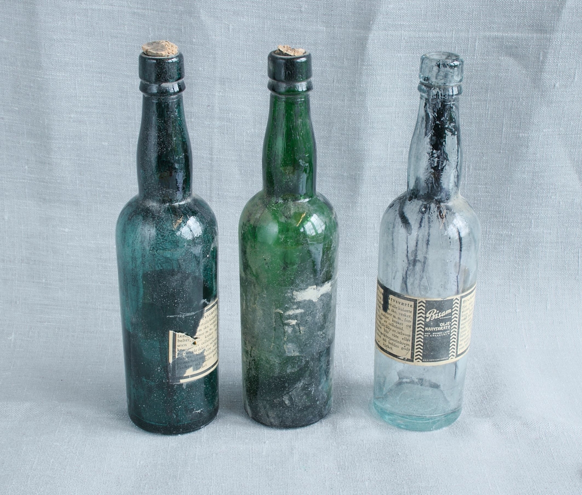 Tre glassflasker som har inneholdt narvsverte for sverting av skinn.